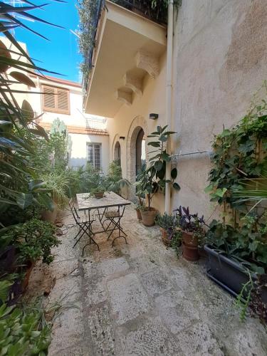 a patio with a table and a bunch of plants at Residenza Bagolino in Alcamo
