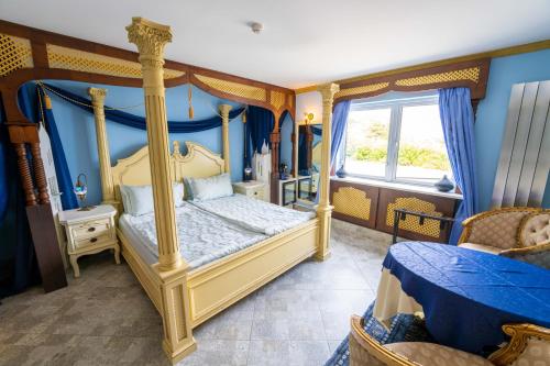 - une chambre avec un lit à baldaquin et des murs bleus dans l'établissement Ferndale Luxury Boutique Bed & Breakfast, à Keel