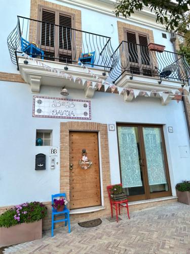 a building with a balcony and a door with two chairs at B&B Savoia San Salvo in San Salvo