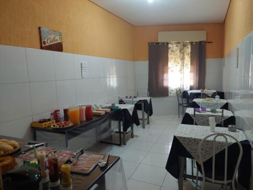 uma sala de jantar com mesas e cadeiras num restaurante em Rex Hotel em Marília