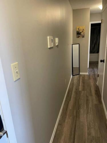 an empty room with a hallway with wood floors at Exquisite 2 Bedroom Apartment in Camrose
