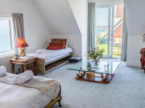 a living room with two beds and a glass table at Cliffhanger in Hollington
