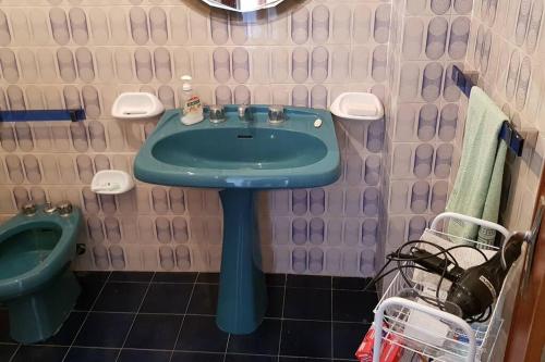 ein Badezimmer mit einem grünen Waschbecken und einem WC in der Unterkunft La casa di Enzo in Noli