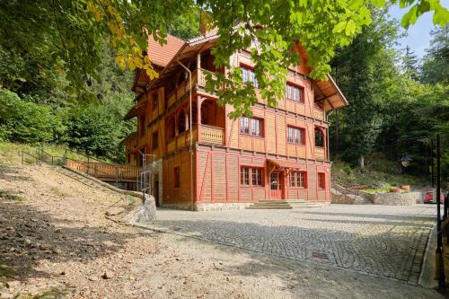 een groot houten gebouw aan de kant van een weg bij Villa Winkler in Miedzygorze