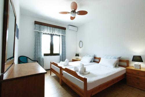 1 dormitorio con 2 camas y ventilador de techo en Villa Paradiso, en Neos Marmaras