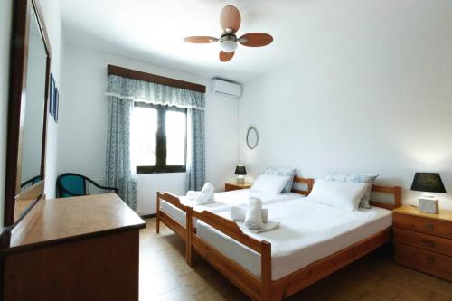 a bedroom with two beds and a ceiling fan at Villa Paradiso in Neos Marmaras