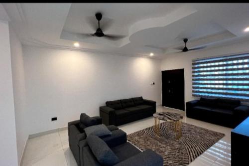 uma sala de estar com dois sofás e uma mesa em Obaatanpa Villa em Acra