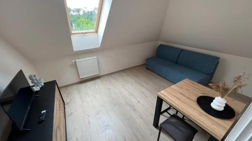 a living room with a blue couch and a table at Kraken-pokoje gościnne in Krynica Morska