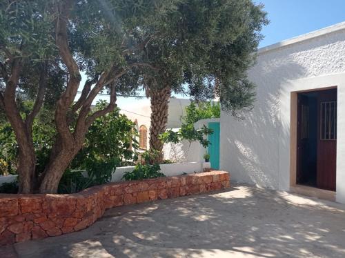 una casa con un árbol y una pared de piedra en Villa Garrido, en El Pozo de los Frailes