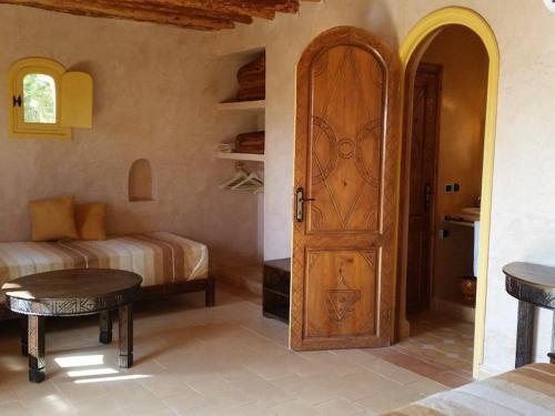 a room with a door and a bedroom with a bed at Paradis Nomade in Azrarag