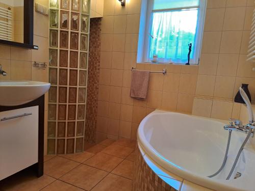 a bathroom with a tub and a sink at Willa Słoneczna - Magdalena i Michał Żelewscy in Karwieńskie Błoto Pierwsze