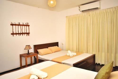 a hotel room with two beds and a window at Leisure House Safari in Udawalawe