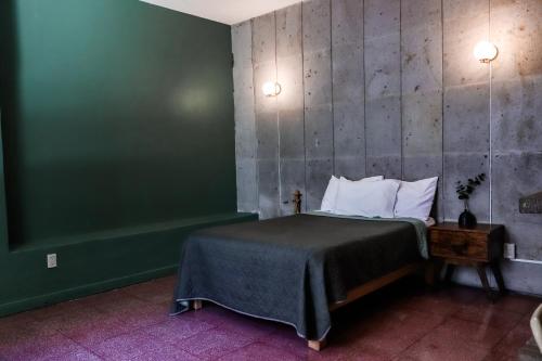 a bedroom with a bed and a green wall at Casa Sabina in Guadalajara