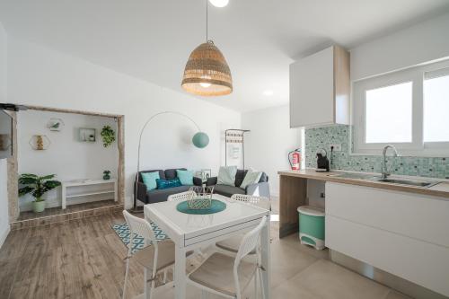 a kitchen and living room with a white table and chairs at Casa das Andorinhas in Sintra