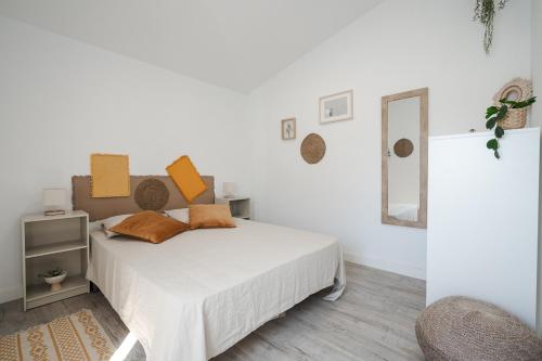 um quarto branco com uma cama e um espelho em Casa das Andorinhas em Sintra