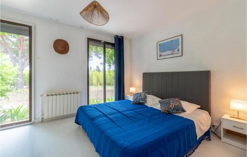 een slaapkamer met een bed met blauwe lakens en een raam bij Lovely Home In Vias With Outdoor Swimming Pool in Vias