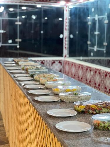 a buffet line with plates and bowls of food at Lulua luxury camp in Wadi Rum