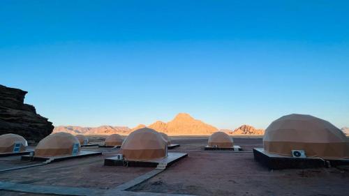 a row of domed tents in the desert at Lulua luxury camp in Disah