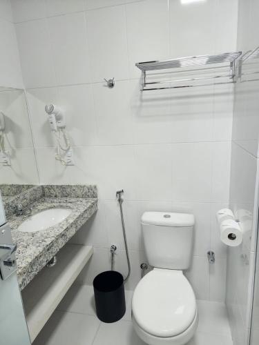a white bathroom with a toilet and a sink at Spazzio Di Roma e parque Acqua Park-Splash in Caldas Novas