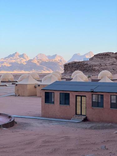 a building in the desert with mountains in the background at Lulua luxury camp in Wadi Rum