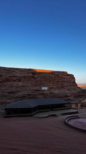 a building in front of a rocky cliff at Lulua luxury camp in Wadi Rum