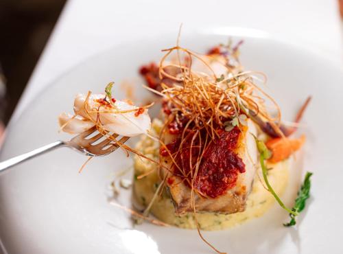 a plate of food with meat and vegetables on a fork at InterContinental Porto - Palacio das Cardosas by IHG in Porto