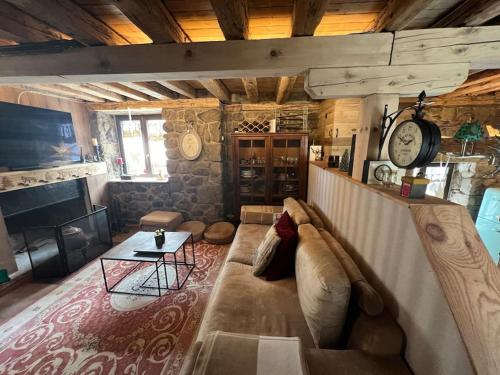 a living room with a couch and a clock on the wall at El 15 de Betren in Betrén