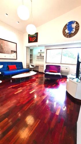 a living room with a blue couch and wooden floors at Loft de lujo ubicado en zona inmejorable Altamira in Caracas