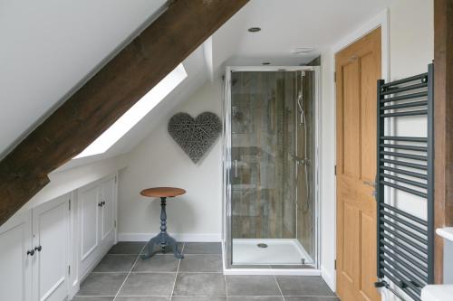 a bathroom with a glass shower and a stool at Stay on the Hill - Self Catered Cottages Laverick and Bothy in Hexham