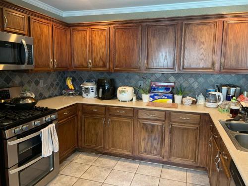 uma cozinha com armários de madeira e um forno com placa de fogão em Private Cozy Lock Room 1 em Cypress