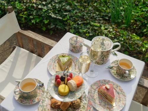 a table with plates of food and cups of coffee at The Baker House 1650 in East Hampton