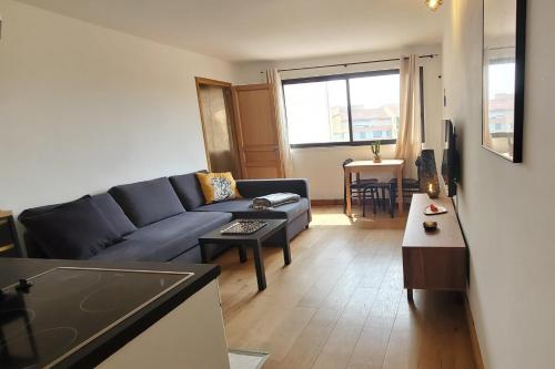 un salon avec un canapé bleu et une table dans l'établissement Modern T2 near train station with swimming pool, à Fréjus