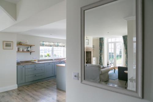 a mirror in a kitchen with a living room at Stay on the Hill - Self Catered Cottages Laverick and Bothy in Hexham