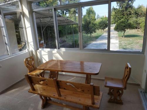 a wooden table and bench in front of a window at Εξοχική Κατοικία - Αγιόκαμπος in Loutra Edipsou