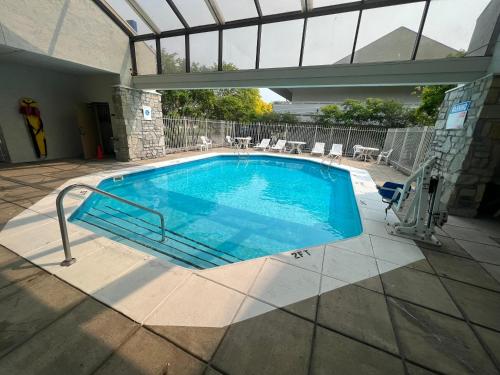 a swimming pool in a building with a glass roof at Days Inn & Suites by Wyndham Monroe in Monroe
