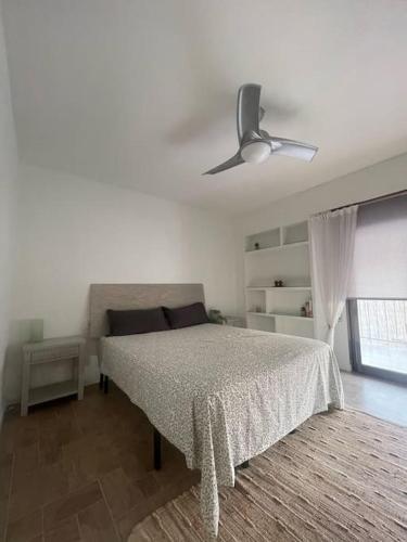 - une chambre avec un lit et un ventilateur de plafond dans l'établissement Precioso duplex y espacioso en la playa de Gandía, à Playa de Gandia