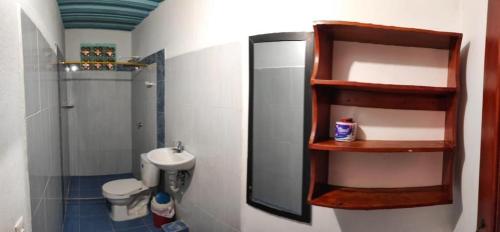 a bathroom with a sink and a toilet and a mirror at kelly tours in Capurganá