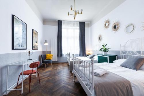 1 dormitorio con cama, escritorio y silla en Friendhouse Apartments Starovislna, en Cracovia