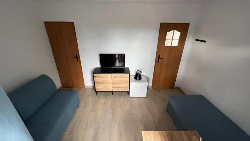 a living room with two doors and a couch at Kraken-pokoje gościnne in Krynica Morska