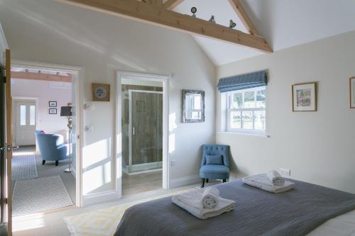a bedroom with a bed and a blue chair at Stay on the Hill - Self Catered Cottages Laverick and Bothy in Hexham