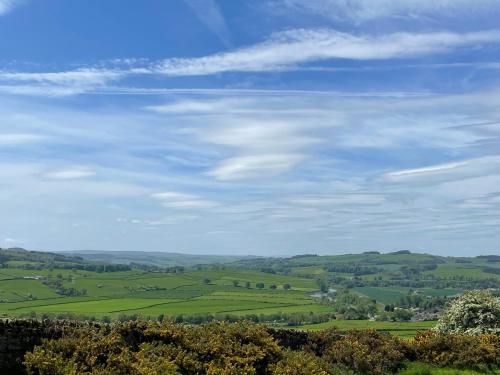 a view of a green field under a cloudy sky at Stay on the Hill - Self Catered Cottages Laverick and Bothy in Hexham
