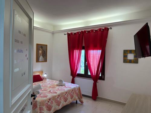 um quarto com uma cortina vermelha e uma janela em Le Sorgenti Guest House em Ilbono