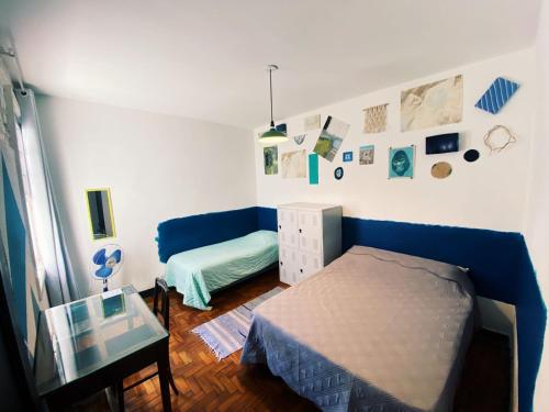 a bedroom with a blue bed and a couch at NeighborHUB hostel e coliving in Sao Paulo