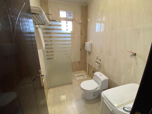 فندق وايت هافن في Sūq al Aḩad: حمام مع دش ومرحاض ومغسلة
