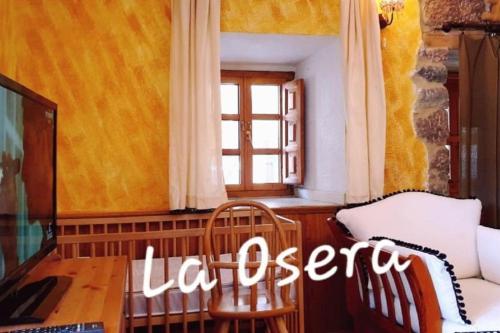 - un salon avec une table, un canapé et une fenêtre dans l'établissement zentralclub La Osera visionando la naturaleza, à Santiago del Hermo