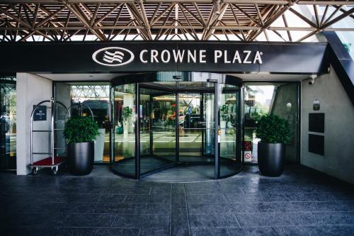 a company entrance with two potted plants in front at Crowne Plaza Belgrade, an IHG Hotel in Belgrade