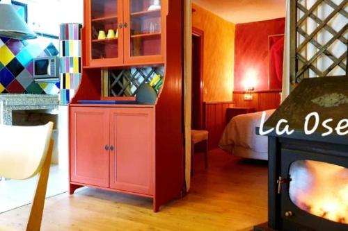 une chambre avec une armoire rouge et une chambre avec un lit dans l'établissement zentralclub La Osera visionando la naturaleza, à Santiago del Hermo