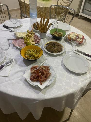a white table with plates of food on it at Villa Marina B&B in Cleto