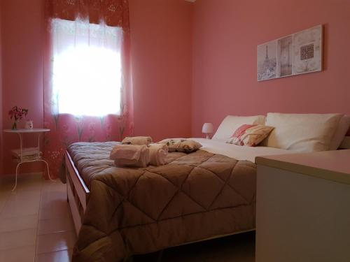 a bedroom with two beds and a window at La Maison di Arya in Riposto