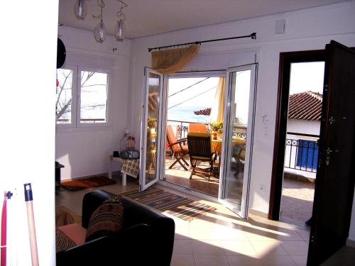 a living room with a door open to a balcony at Beach View Siviri in Siviri
